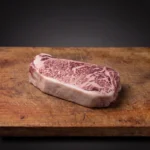 Japanski Wagyu A5 Striploin iz Kagoshime BMS 11–12 na drvenoj dasci