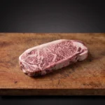 Japanski Wagyu A5 Striploin iz Kagoshime BMS 11–12 na drvenoj dasci