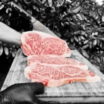 Japanski Wagyu A5 striploin steakovi s izraženom marmorizacijom na drvenoj dasci